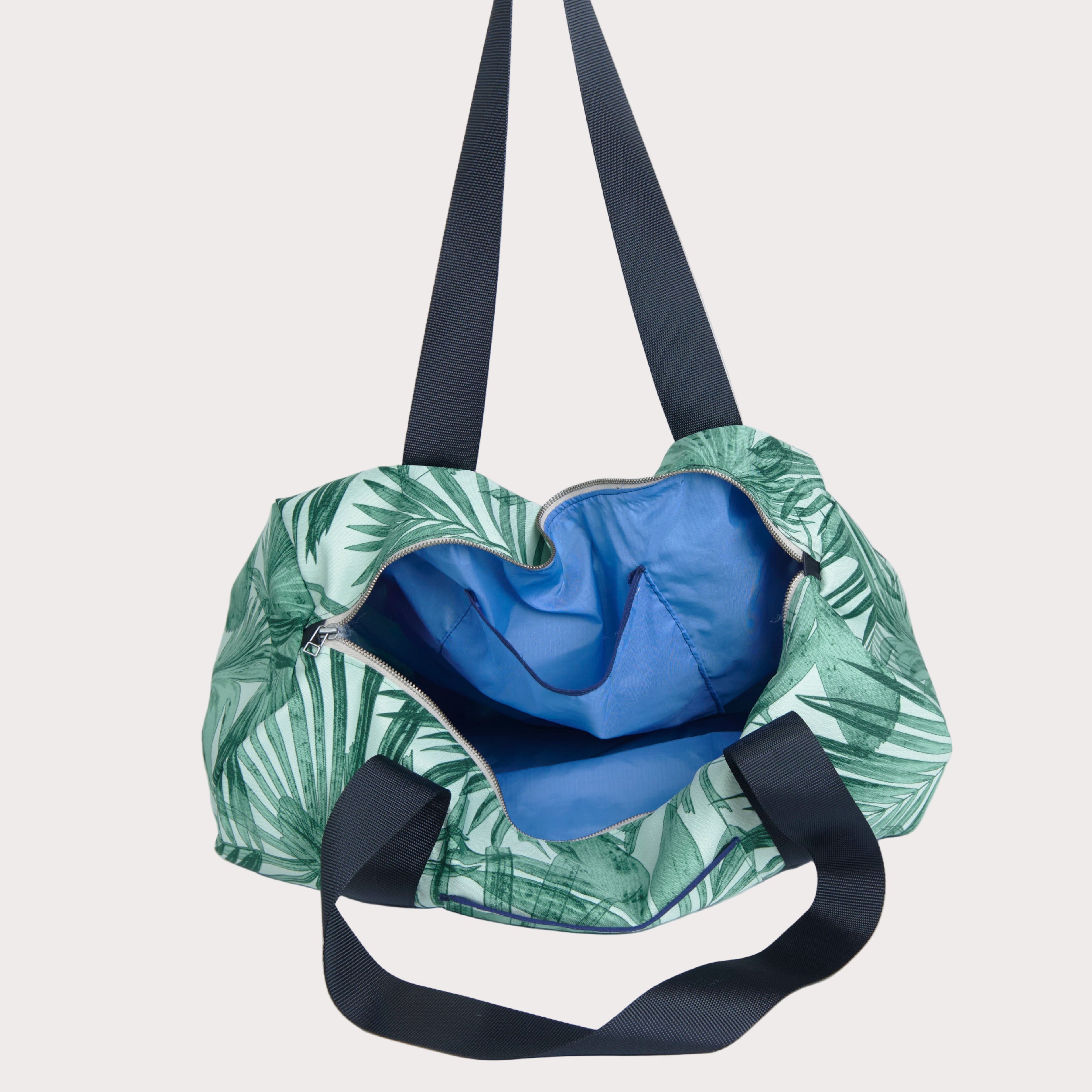 Green leaf-patterned bag with a blue interior on a light gray background