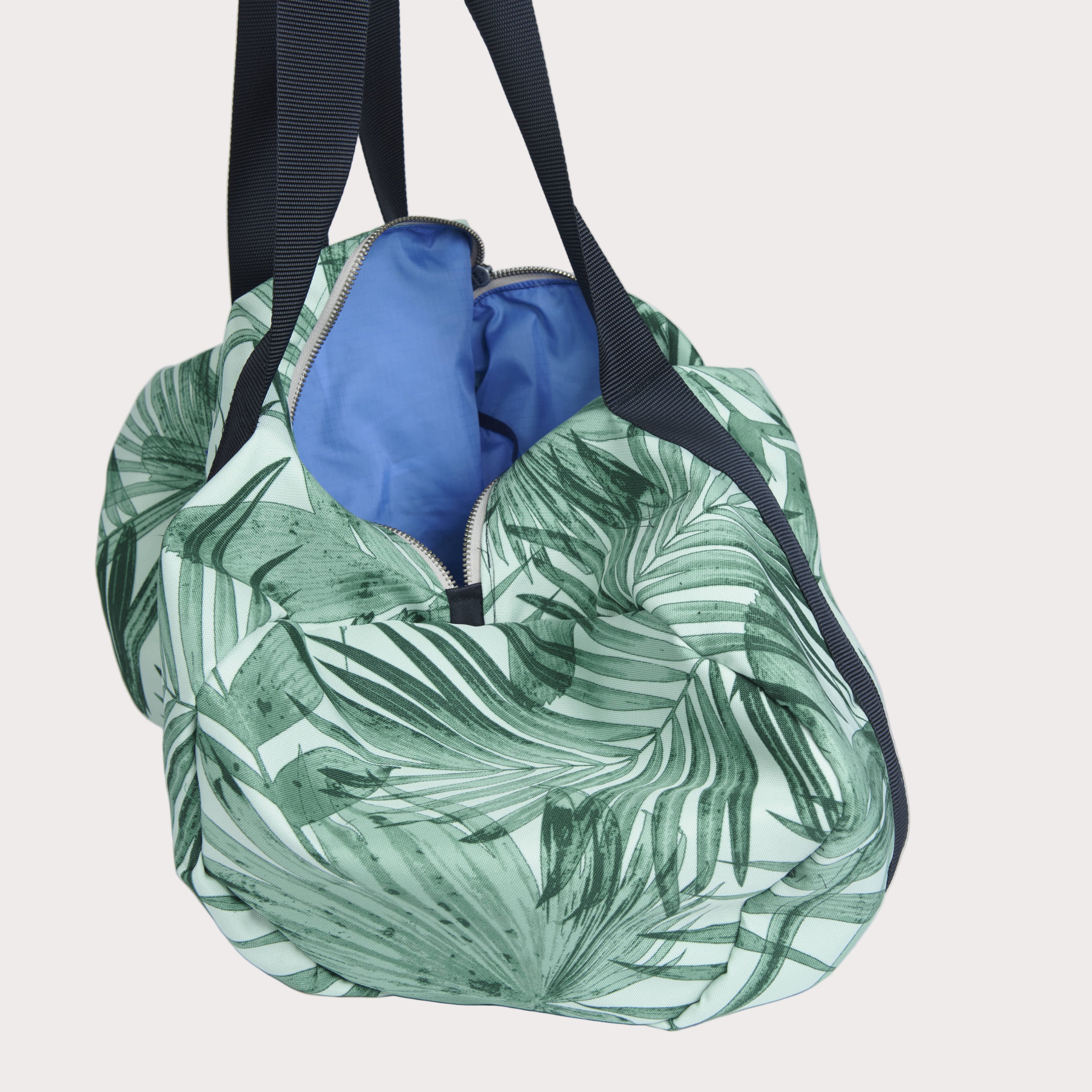 Green leaf-patterned bag with a blue interior on a light gray background