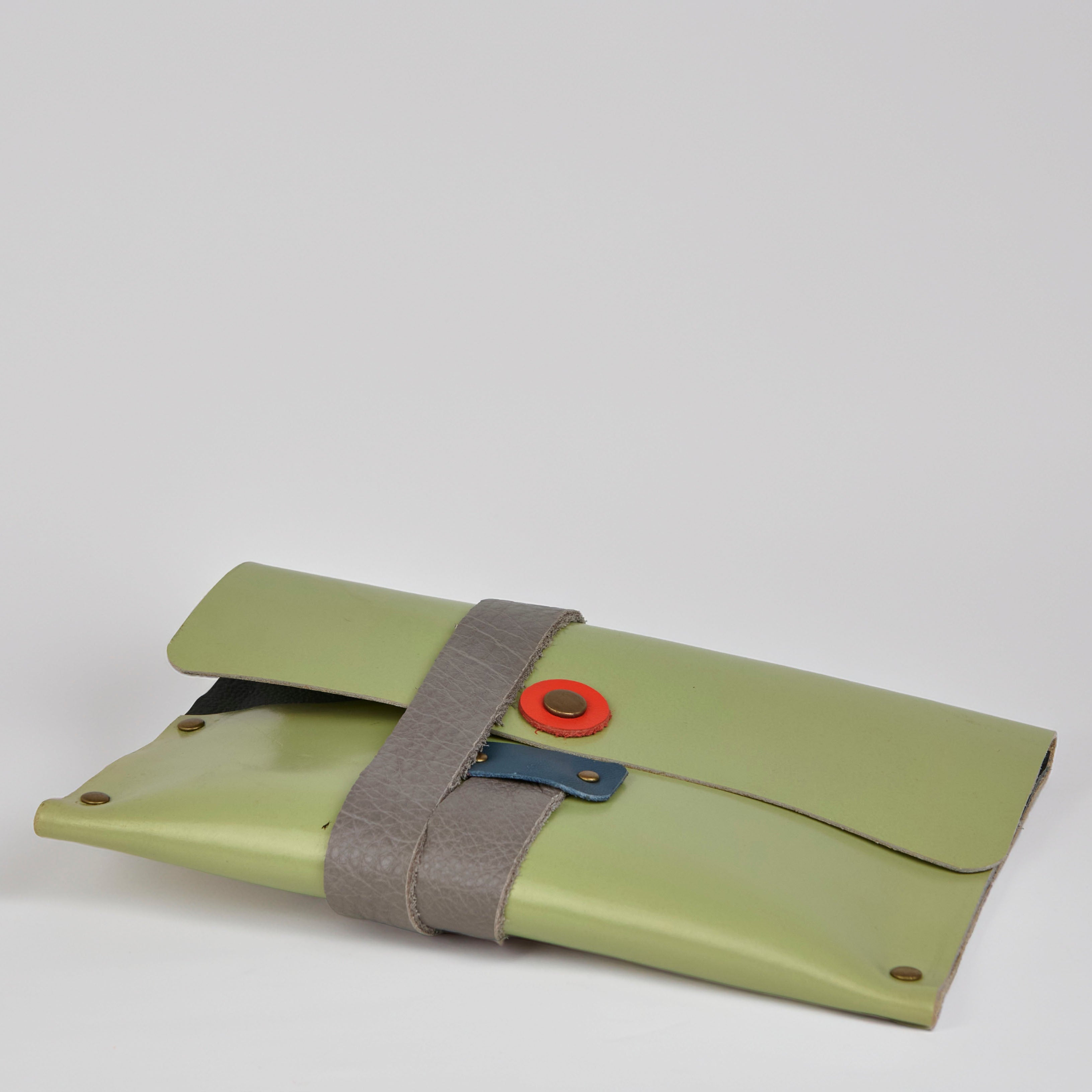 Green leather pouch with a strap and red button on a white background